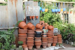 A variety of stacked and hanging garden pots outdoors, showcasing vibrant colors and textures.